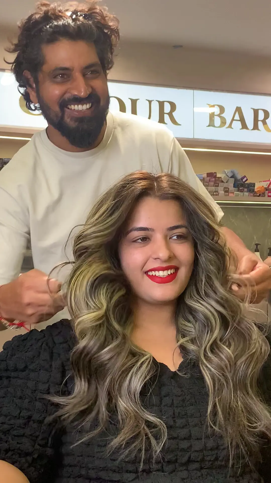 Stylist discussing a reference hairstyle photograph with a client during a hair consultation at Rush Salon, Surat